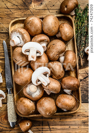 Cut Raw mushrooms brown champignon. wooden background. Top view Cut Raw mushrooms brown champignon. wooden background. Top view 74247809