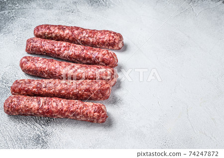Fresh raw beef meat kebabs sausages. White background. Top view. Copy space Fresh raw beef meat kebabs sausages. White background. Top view. Copy space 74247872