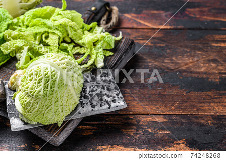 Sliced Savoy cabbage on cutting board. Dark wooden background. Top view. Copy space Sliced Savoy cabbage on cutting board. Dark wooden background. Top view. Copy space 74248268