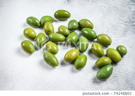 Fresh Green big olives on a table. White background. Top view Fresh Green big olives on a table. White background. Top view 74248601
