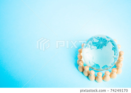 Image of people holding hands with the earth Glass globe and miniature doll 74249170