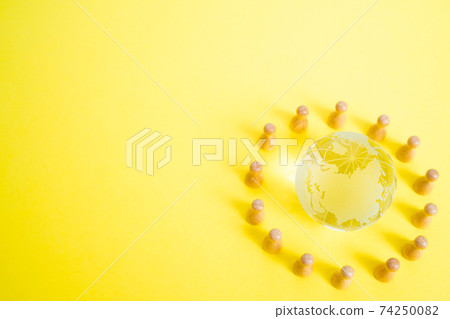 Image of people holding hands with the earth Glass globe and miniature doll 74250082