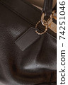 Black tag on genuine pebble leather bag with gold furniture 74251046