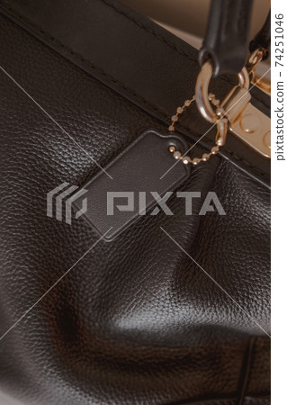 Black tag on genuine pebble leather bag with gold furniture 74251046