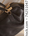 Black tag on genuine pebble leather bag with gold furniture 74251047