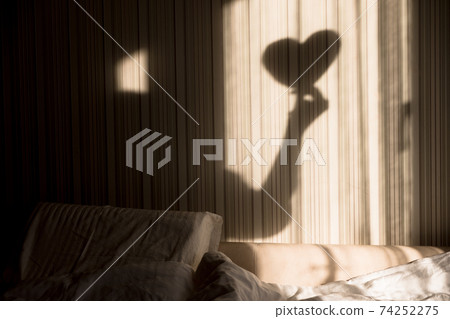 Woman making heart shadow on the wall. World mental health day, hope and love. Valentines 14 February Woman making heart shadow on the wall. World mental health day, hope and love. Valentines 14 February 74252275