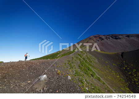 Climbers and the summit of Mt. Fuji near the Hoei crater Climbers and the summit of Mt. Fuji near the Hoei crater 74254549