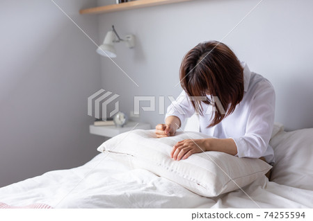 A woman hits a pillow in bed and is angry Hysterical sad sad bed A woman hits a pillow in bed and is angry Hysterical sad sad bed 74255594