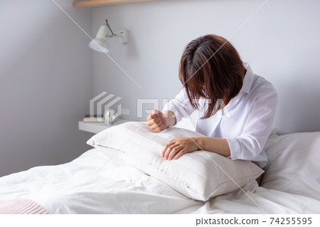 A woman hits a pillow in bed and is angry Hysterical sad sad bed A woman hits a pillow in bed and is angry Hysterical sad sad bed 74255595