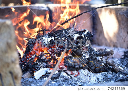 熊熊燃燒的火焰舊的新年裝飾品和幸運符變成木炭和灰燼,帶有潔淨的火焰 熊熊燃燒的火焰舊的新年裝飾品和幸運符變成木炭和灰燼,帶有潔淨的火焰 74255869