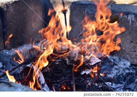 熊熊燃燒的火焰舊的新年裝飾品和幸運符變成木炭和灰燼,帶有潔淨的火焰 熊熊燃燒的火焰舊的新年裝飾品和幸運符變成木炭和灰燼,帶有潔淨的火焰 74255872