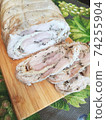 chicken roll with omelette and spices on a wooden board. 74255904