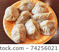traditional manti with lamb and spices on a plate on the table. 74256021