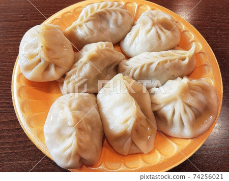 traditional manti with lamb and spices on a plate on the table. traditional manti with lamb and spices on a plate on the table. 74256021