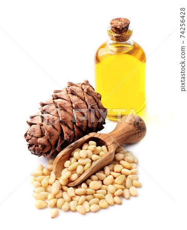 Healthy pine oil, cone cedar and pine nuts isolated on white backgrounds. Healthy pine oil, cone cedar and pine nuts isolated on white backgrounds. 74256428