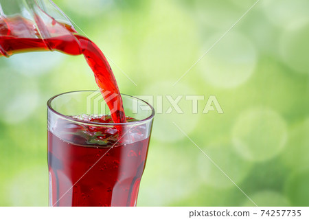juice pouring into glass 74257735