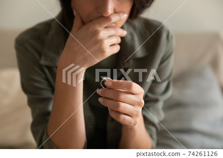 Close up of woman hold ring think of divorce 74261126