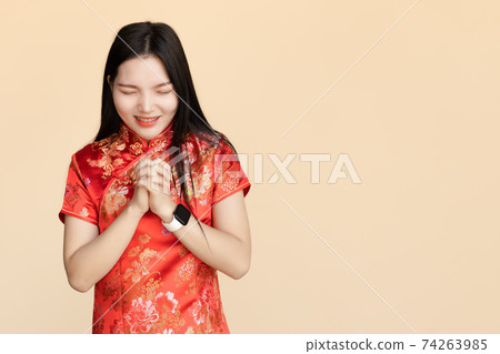 Chinese women dressing Qipao traditional cloth Make a wish or pray in Chinese New Year festival with copy space. Chinese women dressing Qipao traditional cloth Make a wish or pray in Chinese New Year festival with copy space. 74263985