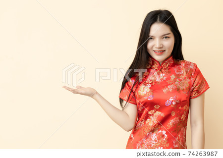 Chinese teen girl in present show giving or sale promotion posture dressing Qipao traditional cloth. 74263987