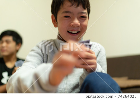 Family playing cards happily in 3 generations 74264023