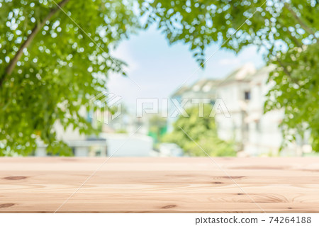 Green town home eco community blur background with wooden table foreground space for products advertising template 74264188