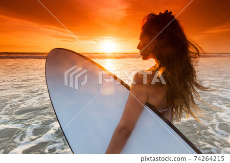 Woman with surfboard on tropical beach Woman with surfboard on tropical beach 74264215