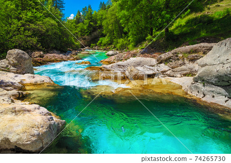 Emerald color Soca river with rocky shore, Bovec, Slovenia 74265730