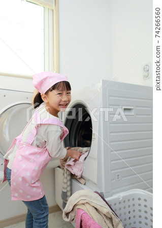 A 5-year-old girl helping to wash clothes 74266560
