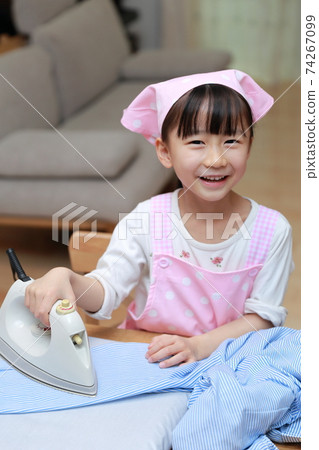 一個5歲的女孩正在幫助熨襯衫 74267099