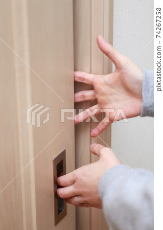 A housewife who gets injured by pinching her fingers when opening and closing the door A housewife who gets injured by pinching her fingers when opening and closing the door 74267258