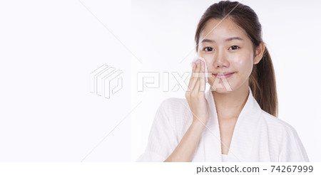 Asian woman wear bathrobe using cotton pad removing make-up on her face fresh skin before bath Asian woman wear bathrobe using cotton pad removing make-up on her face fresh skin before bath 74267999