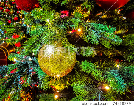 Beautiful Christmas background - shiny baubles on a background of blurred lights on a Christmas tree with bokeh effect. 74268779