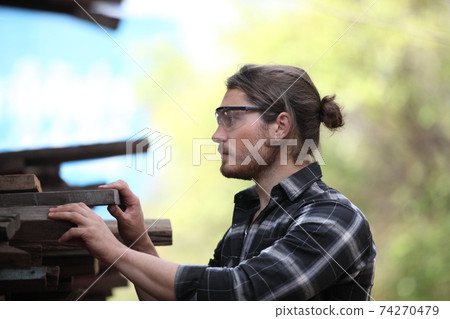 Carpenter, he is working in the workshop. Man at work on wood. Image of mature carpenter in the workshop, furniture making concept. 74270479