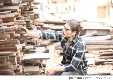 Carpenter, he is working in the workshop. Man at work on wood. Image of mature carpenter in the workshop, furniture making concept. 74270525