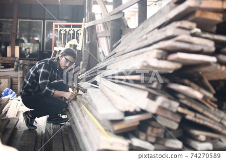 Carpenter, he is working in the workshop. Man at work on wood. Image of mature carpenter in the workshop, furniture making concept. 74270589