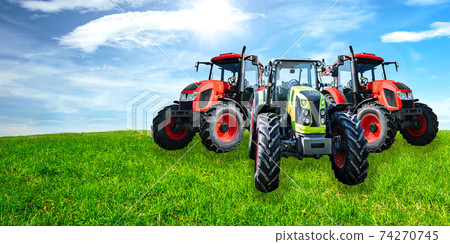 Agricultural advertisement banner - group of new and modern generic tractors on a green meadow in sunny day (mixed). 74270745