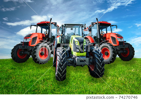 Group of new and modern agricultural generic tractors on a green meadow in sunny day(mixed) 74270746