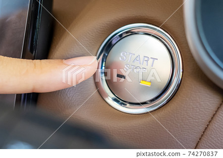 Finger press a car ignition button or START engine inside modern electric automobile. Keyless, change, strategy, vision, innovation and future concept Finger press a car ignition button or START engine inside modern electric automobile. Keyless, change, strategy, vision, innovation and future concept 74270837
