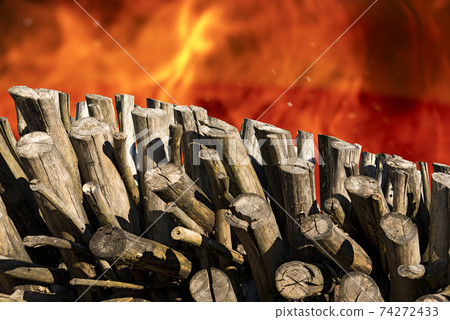 Stack of Firewood with Flames of a Bonfire on Background 74272433