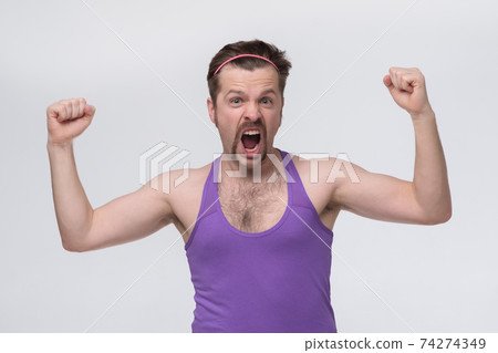 Successful young caucasian male sportsman screaming Yes and raising clenched fists in the air, feeling excited. Successful young caucasian male sportsman screaming Yes and raising clenched fists in the air, feeling excited. 74274349