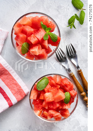 Top view of juicy watermelon pieces in two glass bowls 74275076