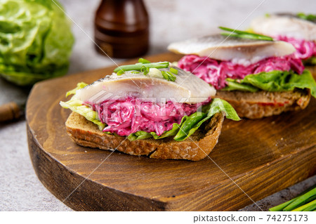 Herring sandwich with beet and green salad Herring sandwich with beet and green salad 74275173