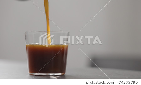 pour coffee in tumbler glass on concrete countertop with copy space 74275799