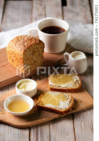 Whole grain bread slices with butter and honey Whole grain bread slices with butter and honey 74275901
