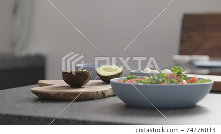 make salad with kale, mozzarella, avocado and cherry tomatoes, remove seed from avocado make salad with kale, mozzarella, avocado and cherry tomatoes, remove seed from avocado 74276013