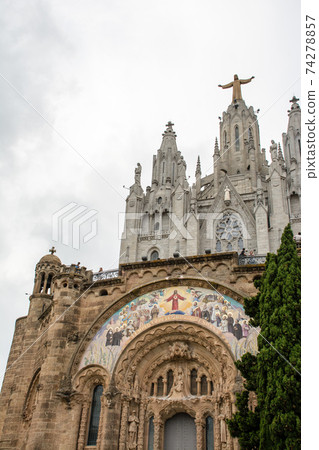 A cathedral with a statue of Christ on top in Barcelona, Spain A cathedral with a statue of Christ on top in Barcelona, Spain 74278857