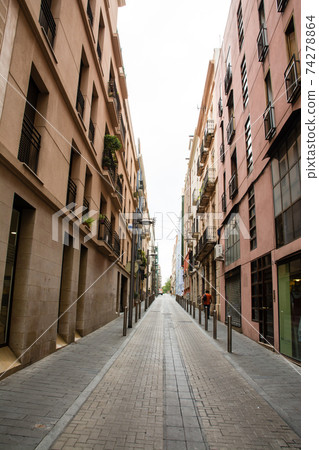 The streets of Tarragona, a suburb of Barcelona, Spain, apartments lined up on both sides of a narrow path 74278864