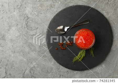 Tray with glass of red caviar, spoon and dill on gray background, space for text Tray with glass of red caviar, spoon and dill on gray background, space for text 74281345
