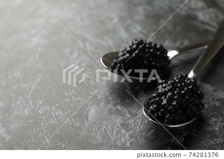 Spoons with black caviar on black smokey background, space for text Spoons with black caviar on black smokey background, space for text 74281376
