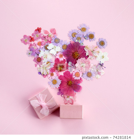 Gift box with flying coloful flowers on pink background. Flat lay. Top view Gift box with flying coloful flowers on pink background. Flat lay. Top view 74281814